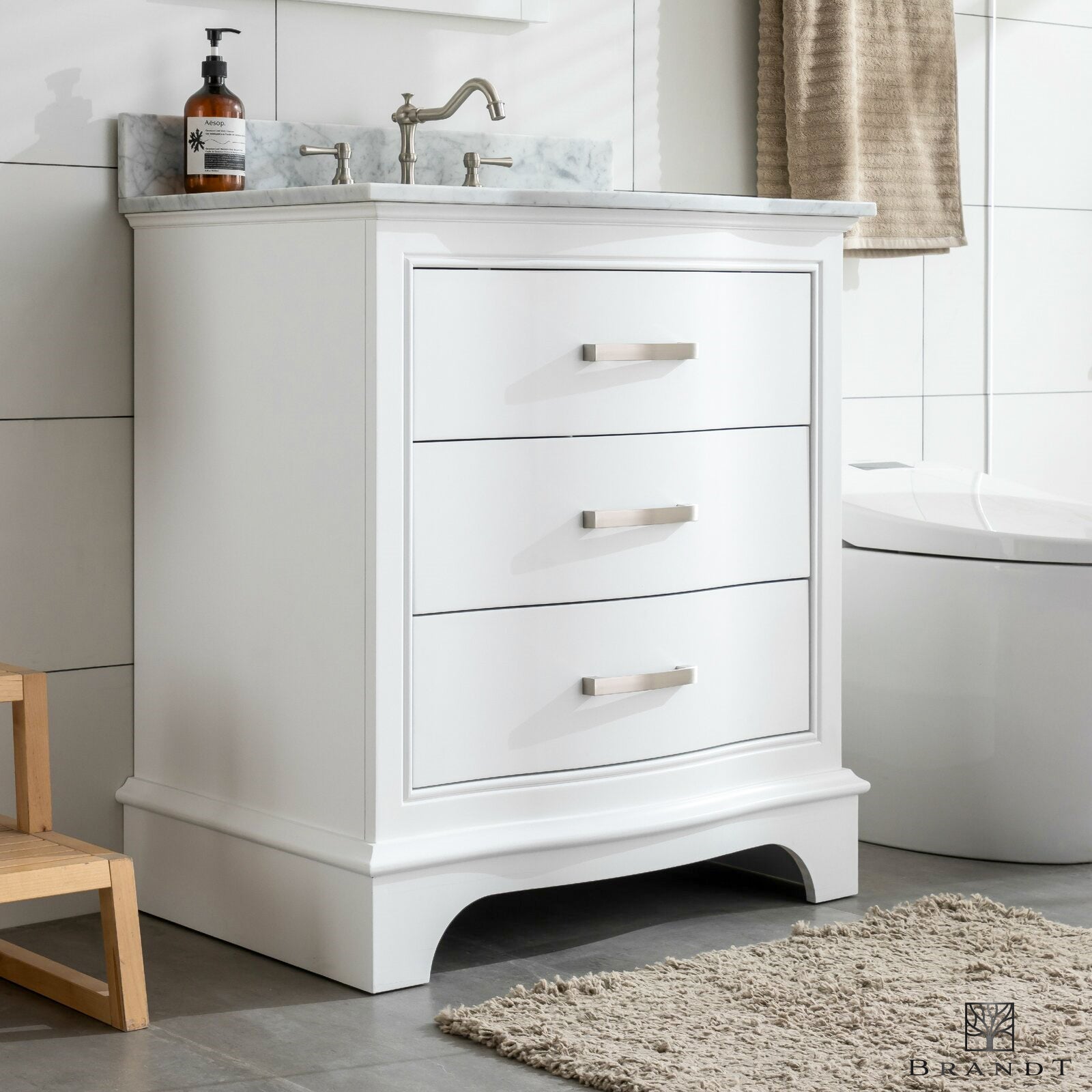 Gulvstående Heltre Servantskap i Klassisk Hvit fra Brandt Bad med Buede Fronter og benkeplate i Carrara Marmor sett skrått forfra.